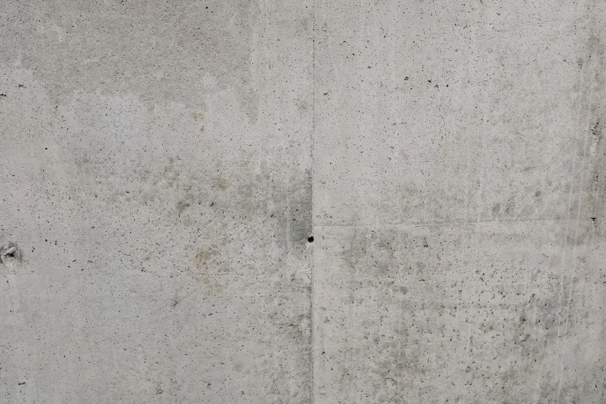 Grijze muur met een betonlook afwerking