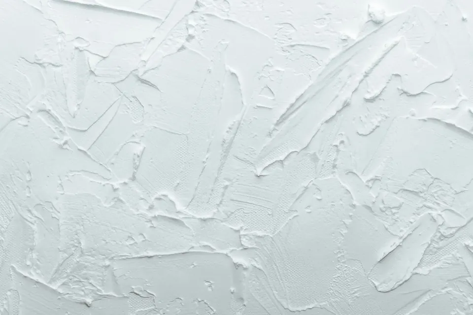 Witte wand met spachtelputz in brede, losse halen