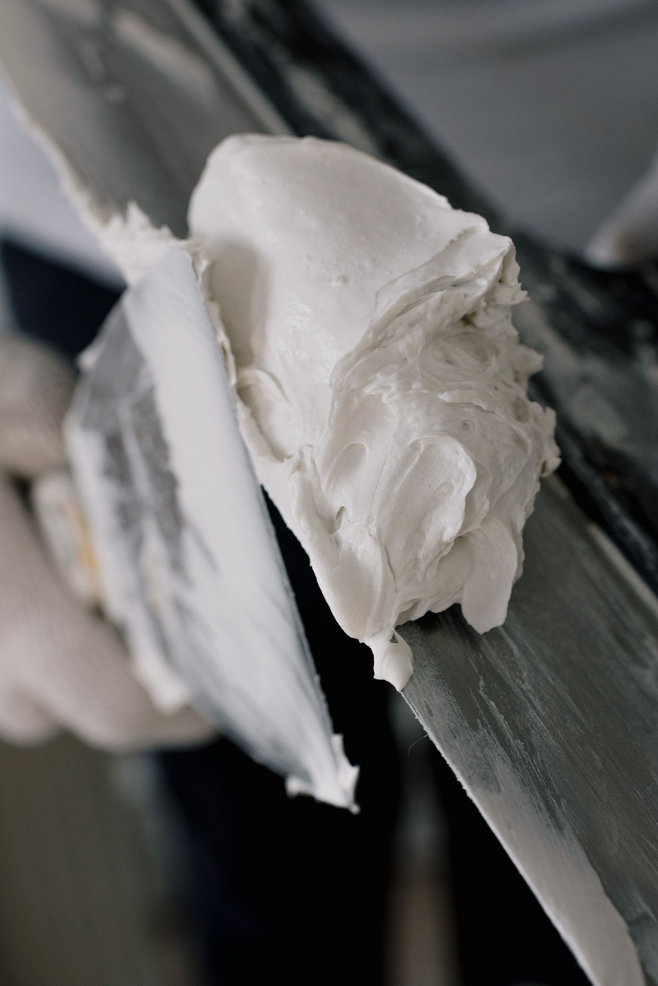 Witte stuc op een metalen troffel in close-up