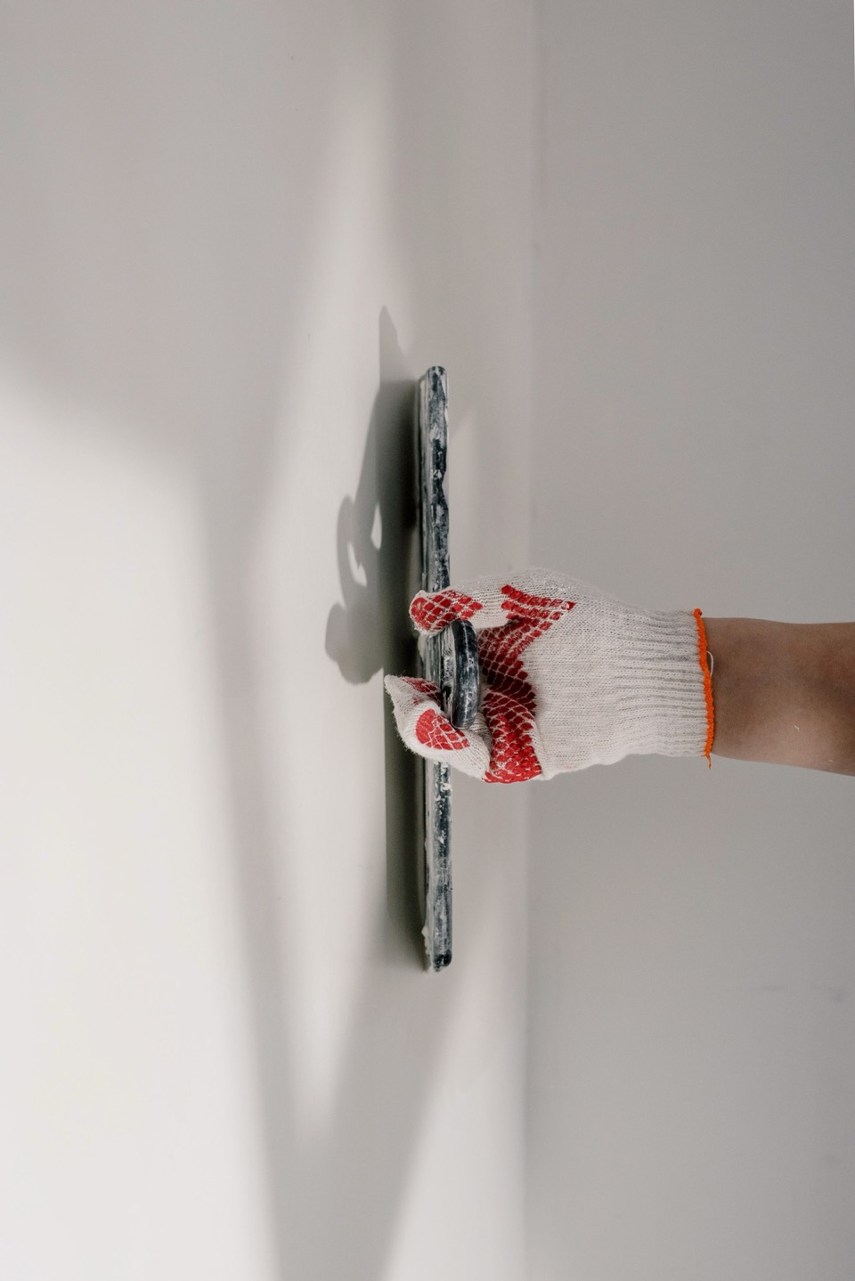 Een plaan glijdt over een nieuw gestucte witte muur